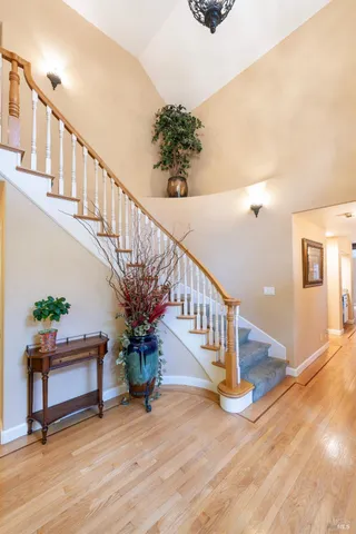 a view of a dining room with furniture a chandelier and large windows