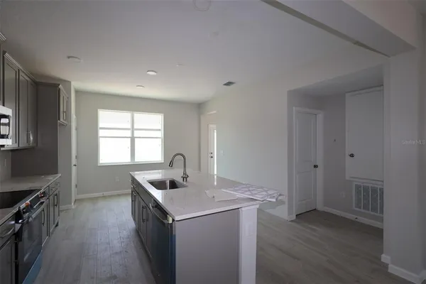 a kitchen with sink cabinets and wooden floor