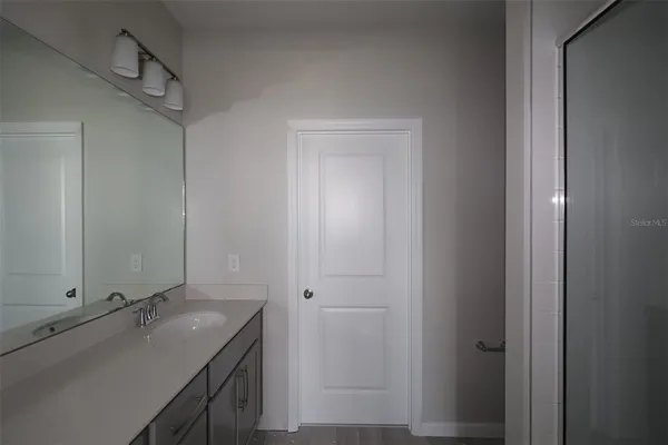 a bathroom with a granite countertop sink and mirror
