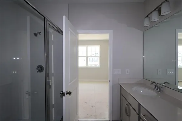 a bathroom with a granite countertop sink mirror and shower