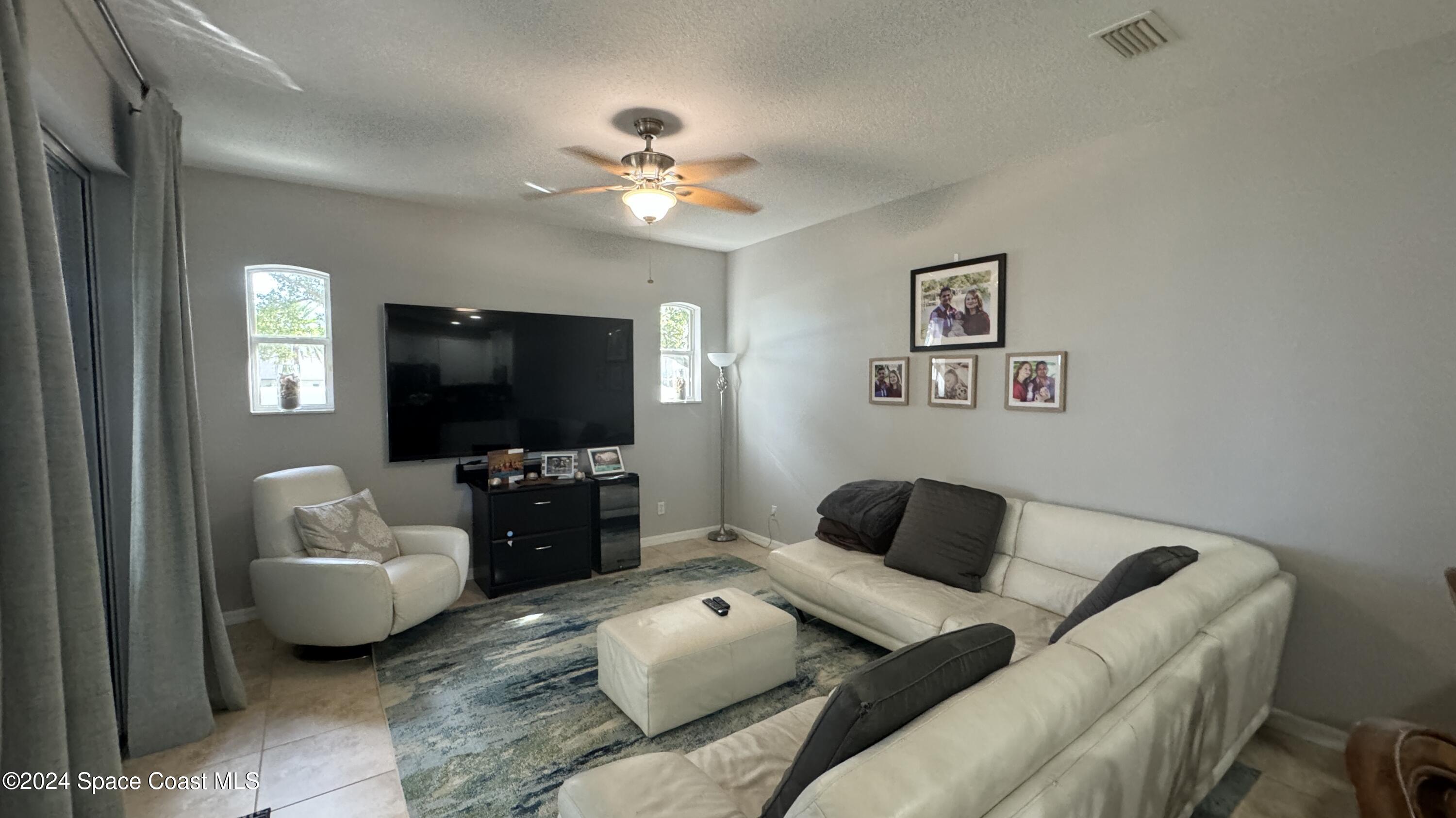 1471 Tamango Drive Melbourne, FL 32904 - Photo 19 of 23 a living room with furniture and a flat screen tv
