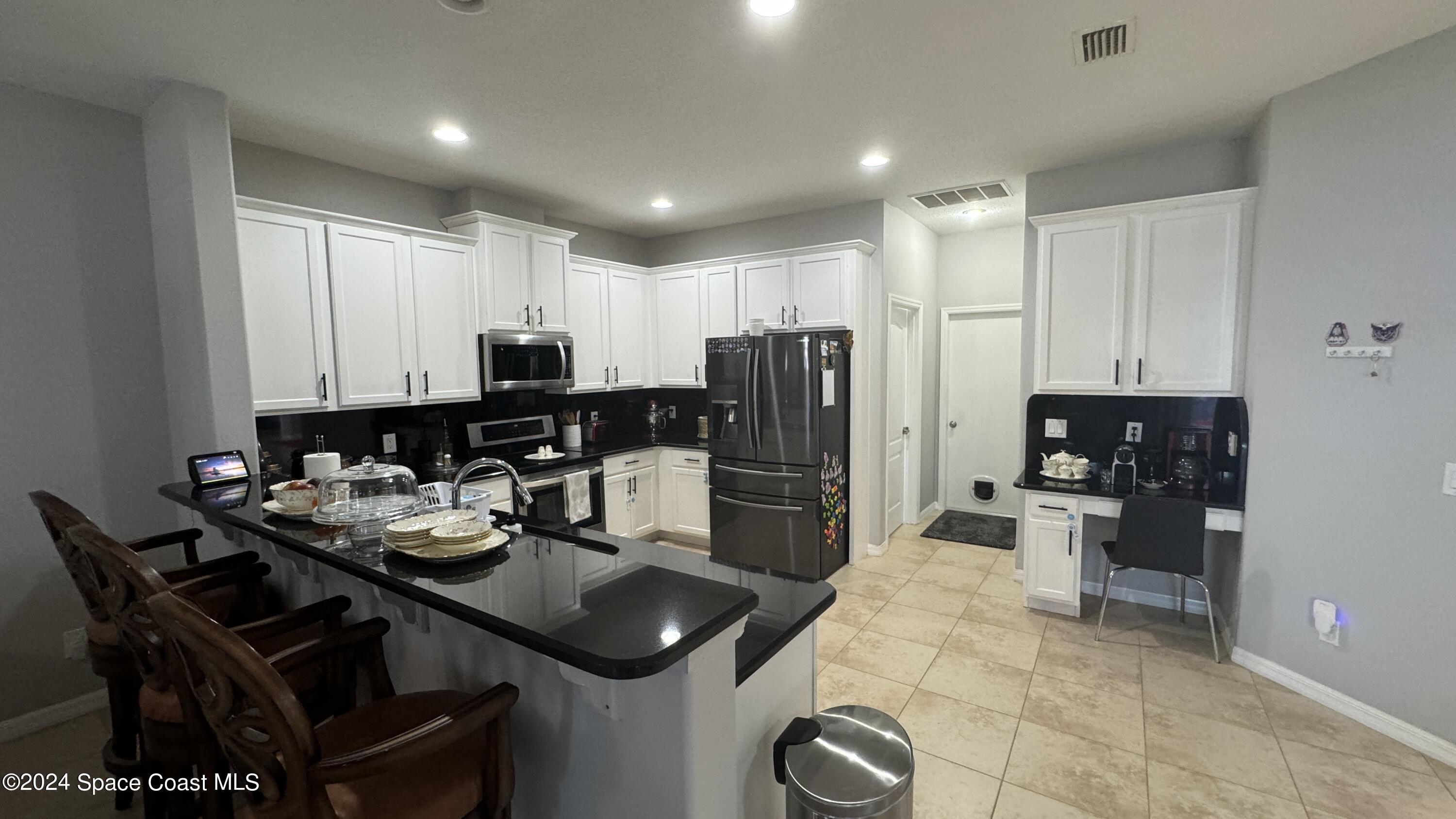 1471 Tamango Drive Melbourne, FL 32904 - Photo 20 of 23 a kitchen with a refrigerator and a stove top oven