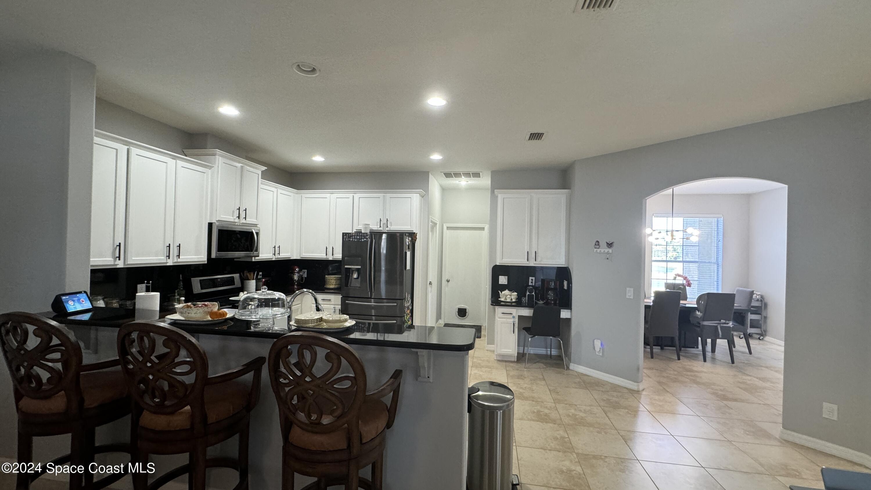 1471 Tamango Drive Melbourne, FL 32904 - Photo 21 of 23 a kitchen with granite countertop a refrigerator and cabinets