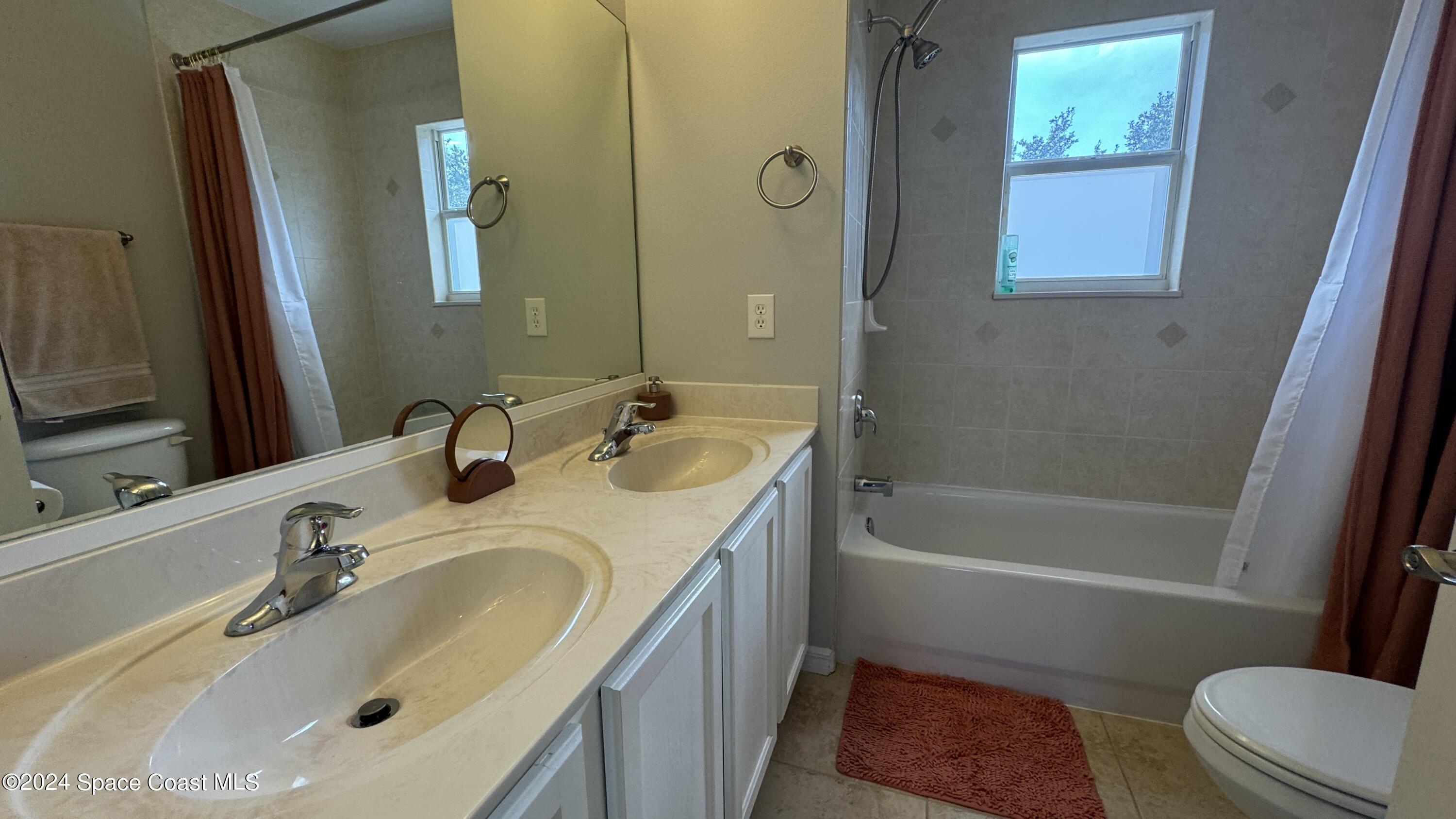 1471 Tamango Drive Melbourne, FL 32904 - Photo 8 of 23 a bathroom with a sink a toilet and a bathtub