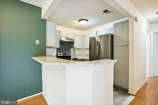 a kitchen with stainless steel appliances a refrigerator and a stove