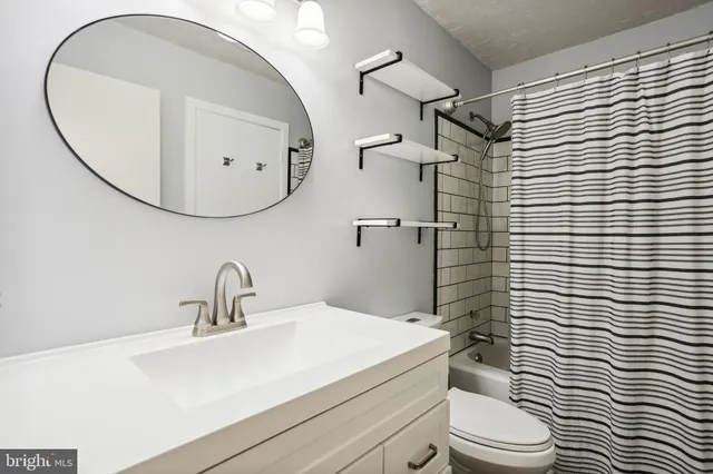 a bathroom with a sink a toilet and shower curtain