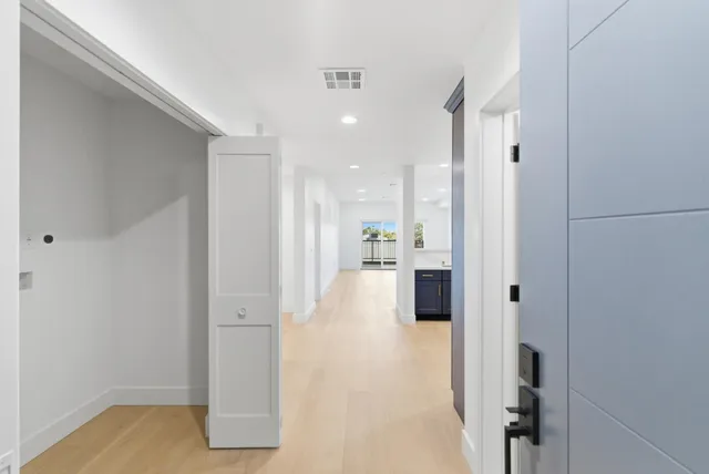 a view of a hallway with wooden floor and cabinet