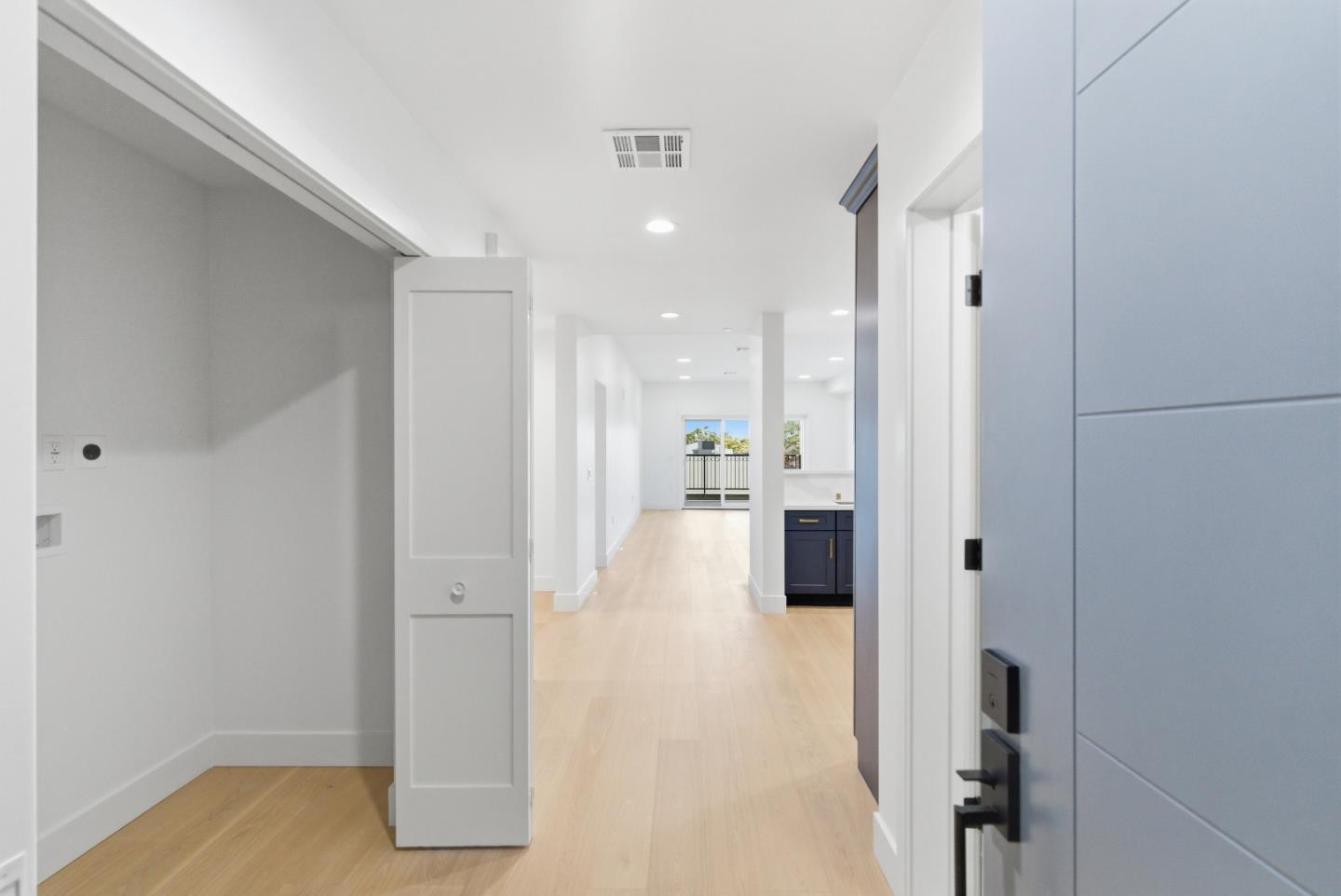 a view of a hallway with wooden floor and cabinet