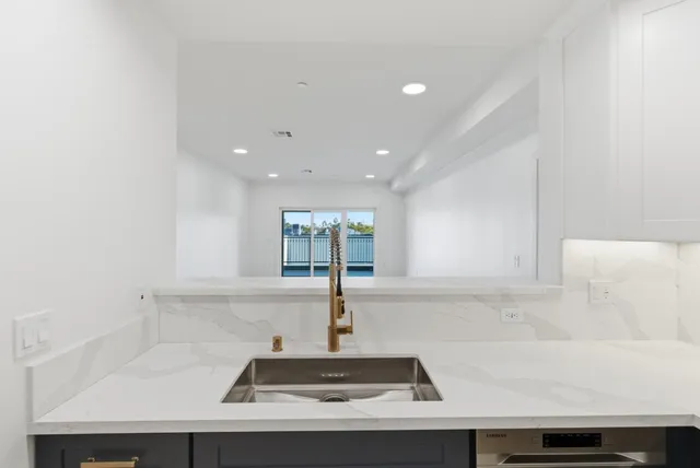 a kitchen with a refrigerator and a stove top oven