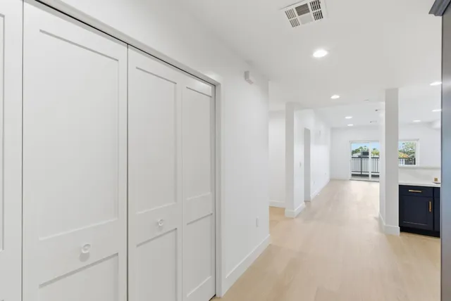 a view of a hallway with wooden shelves