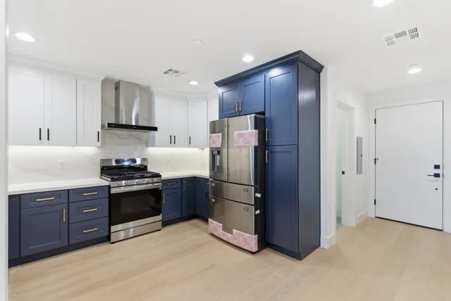 a kitchen with stainless steel appliances granite countertop a refrigerator stove and sink