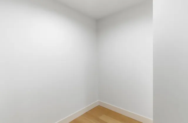 an empty room with glass door and balcony