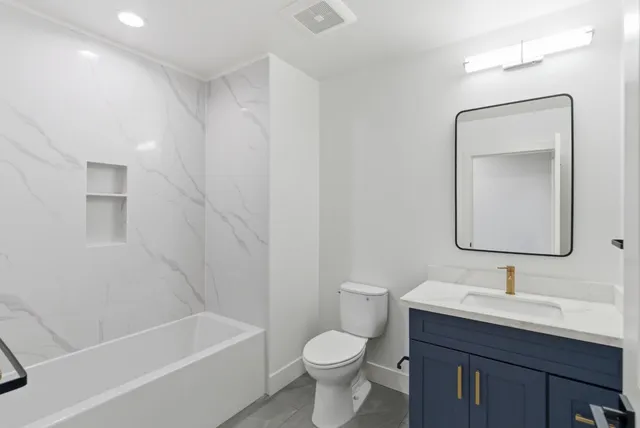 a view of a hallway with kitchen space and a refrigerator