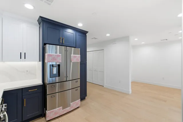 a kitchen with stainless steel appliances a refrigerator and wooden cabinets