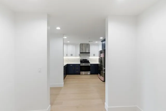 a large white kitchen with a sink and a refrigerator