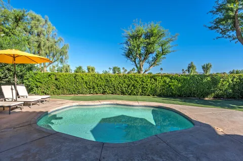 a view of a patio with table and chairs under an umbrella