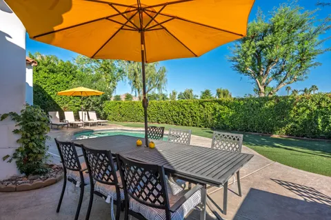 a view of a house with backyard and sitting area