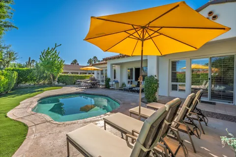 a view of a hallway to a livingroom with wooden floor and windows