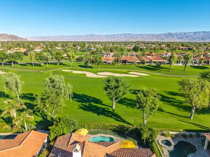 a house with swimming pool and glass top table and chairs