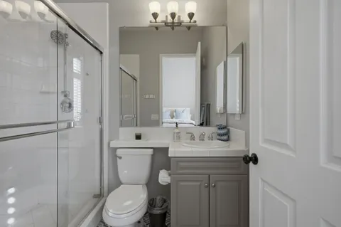 a bathroom with a sink a toilet and shower