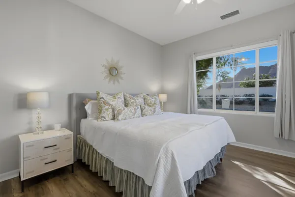 a bedroom with a bed and a table lamp