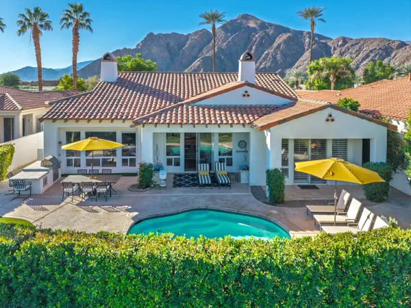 a aerial view of a house with swimming pool and chairs