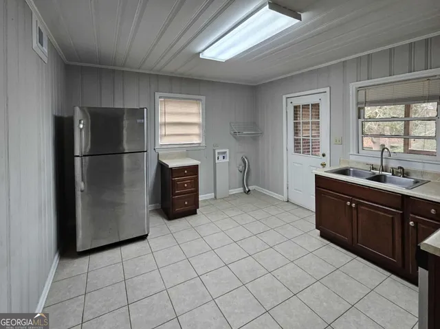 a large kitchen with a refrigerator and a sink
