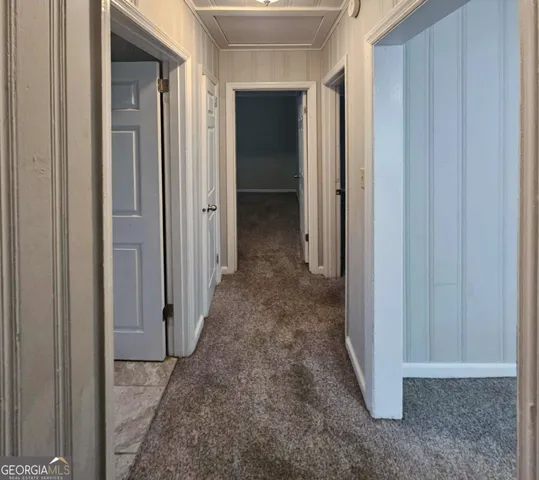 a view of a hallway with wooden shelves