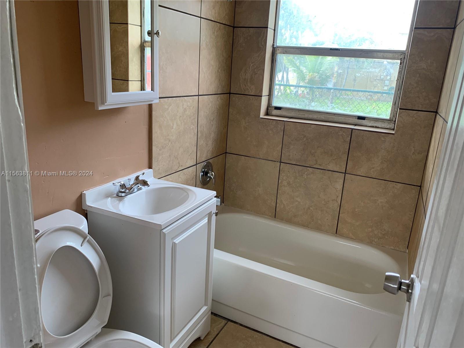 405 Northwest 5th Street, Unit 3 Pompano Beach, FL 33060 - Photo 3 of 6 a bathroom with a sink and bathtub with shower