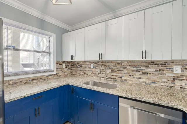 a kitchen with granite countertop white cabinets and a sink