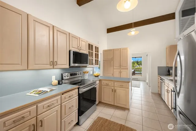 a kitchen with stainless steel appliances granite countertop a refrigerator oven a sink dishwasher and white cabinets with wooden floor