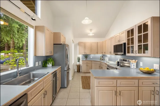 a kitchen with stainless steel appliances granite countertop a sink a stove and a refrigerator