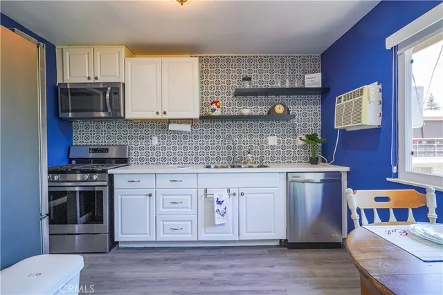a kitchen with stainless steel appliances a sink stove and cabinets