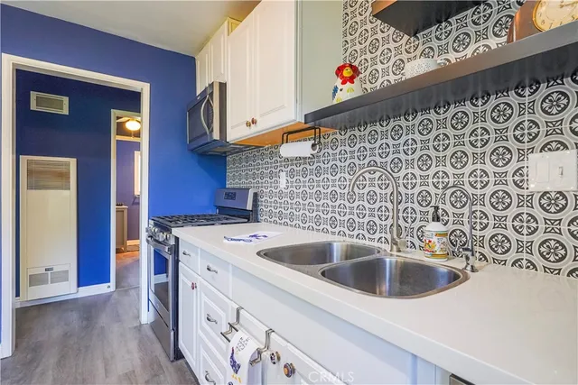 a kitchen with stainless steel appliances a sink a stove and a refrigerator