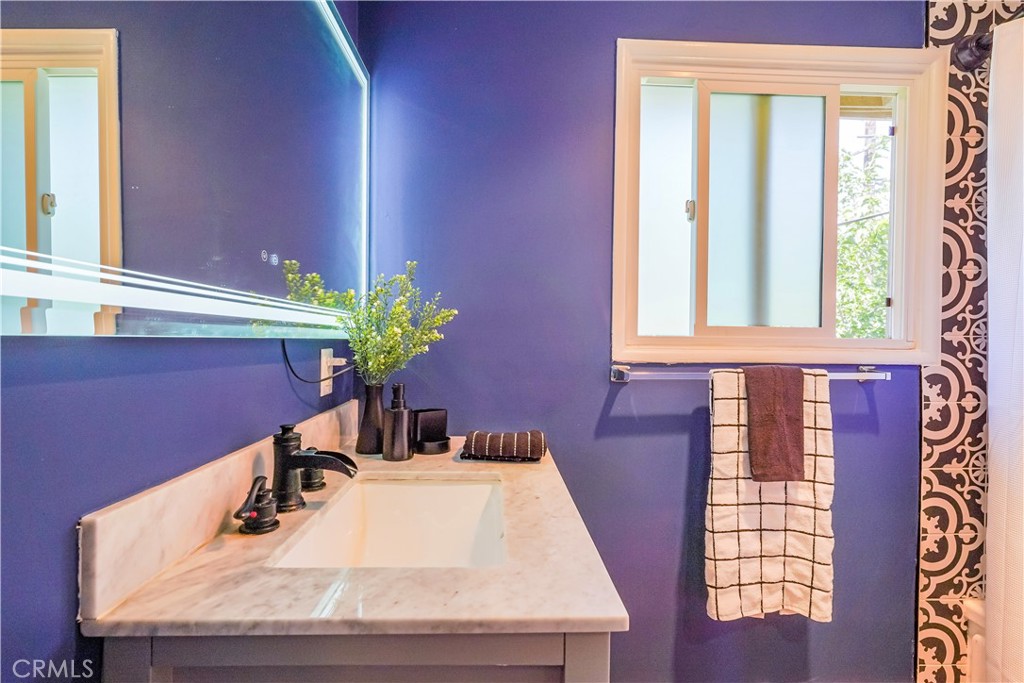 163 North Center Street Redlands, CA 92373 - Photo 22 of 37 a bathroom with a granite countertop sink and a mirror