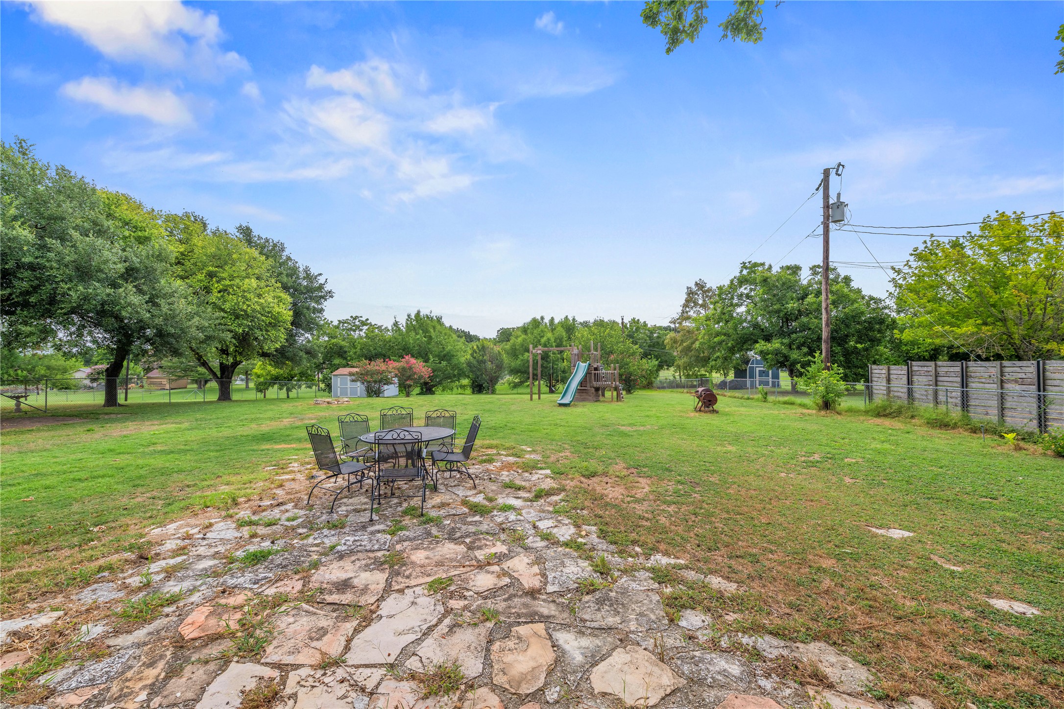 1329 Quail Ravine Round Rock, TX 78664 - Photo 16 of 39 A spacious grassy lawn features a flagstone patio area surrounded by mature shade trees.