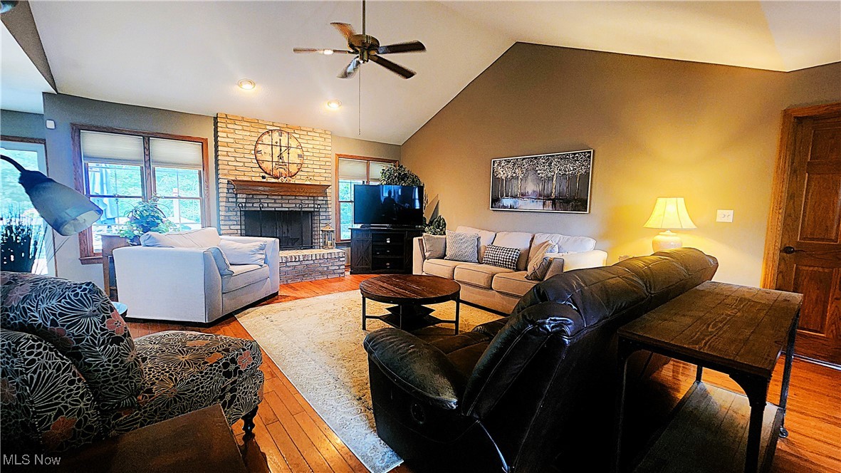 8329 Seasons Road Streetsboro, OH 44241 - Photo 14 of 35 Living room featuring a brick fireplace, brick wall, hardwood / wood-style floors, and lofted ceiling