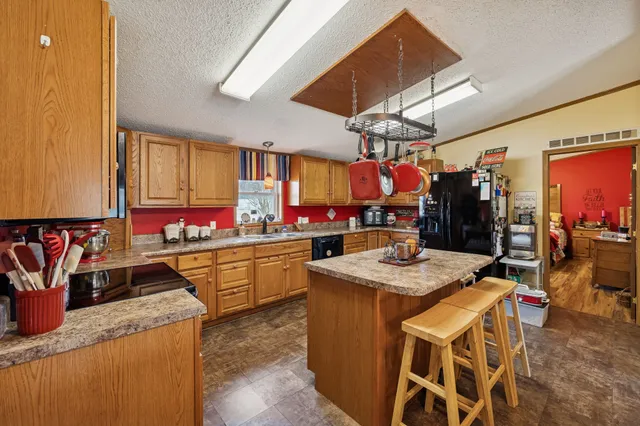 a kitchen with stainless steel appliances granite countertop a sink a stove and a dining table