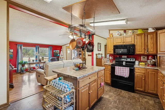 a kitchen with a stove a sink dishwasher and a dining table with wooden floor