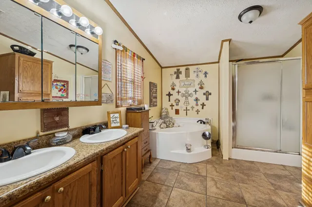 a bathroom with a granite countertop sink a mirror a bathtub and shower