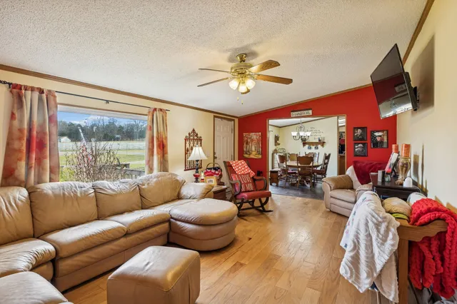 a living room with furniture a flat screen tv and a window