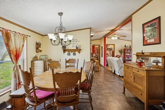 a view of a dining room with furniture a chandelier and wooden floor