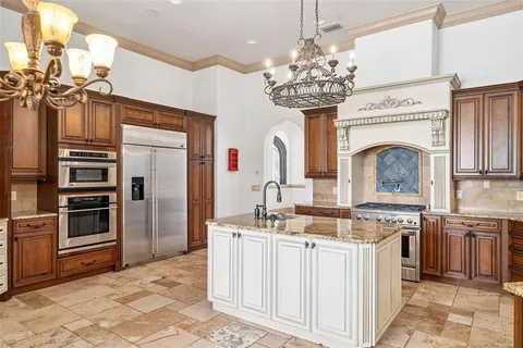 a spacious kitchen with a sink stove and refrigerator