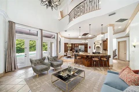 a living room with furniture kitchen view and a large window