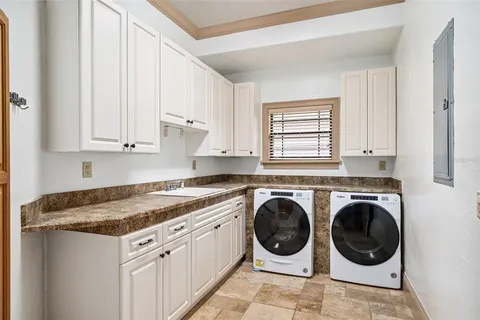 a utility room with sink dryer and washer