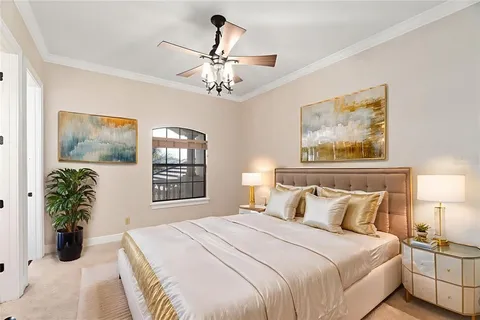 a bedroom with a large bed and a chandelier