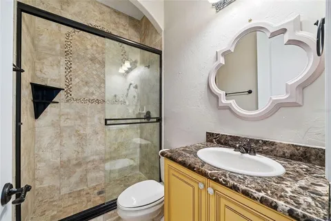 a bathroom with a sink vanity mirror and toilet