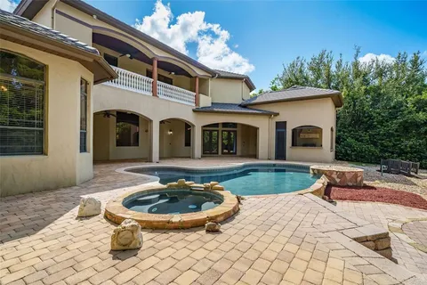 a view of a white house with swimming pool and furniture