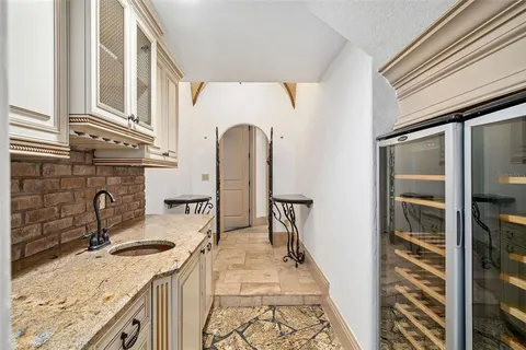 a kitchen with granite countertop a sink stove and refrigerator