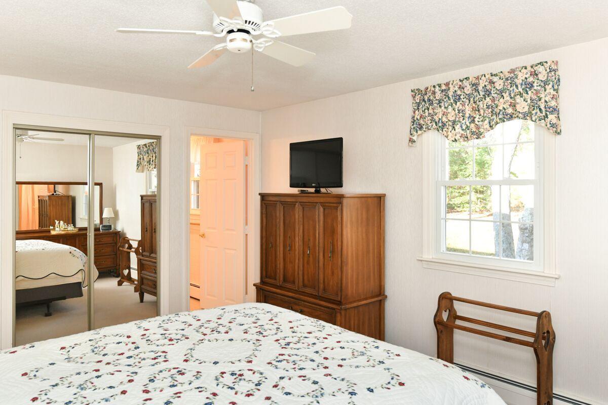 254 Cedric Road Centerville, MA 02632 - Photo 14 of 24 a bedroom with a bed and a flat tv screen on dresser